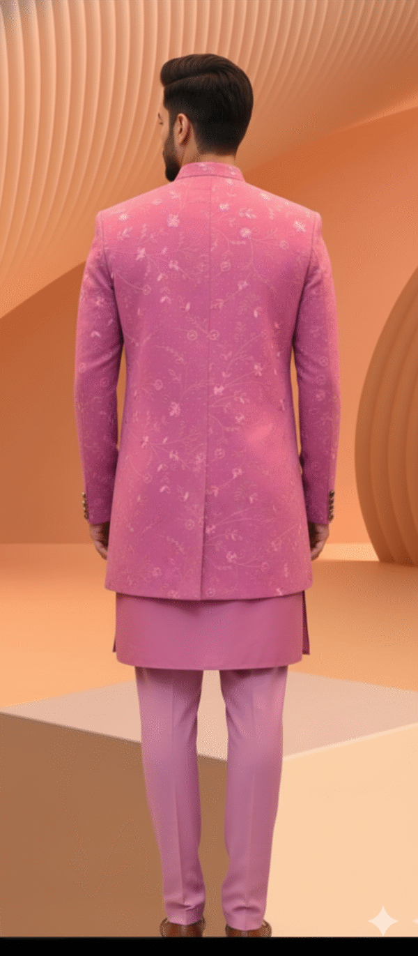 A man wearing a pink embroidered Indo-Western sherwani with a brooch and matching pants.