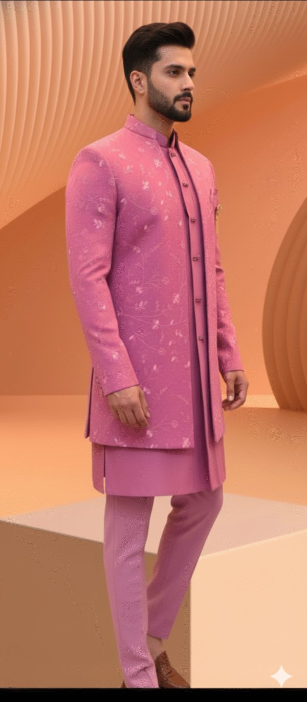 A man wearing a pink embroidered Indo-Western sherwani with a brooch and matching pants.