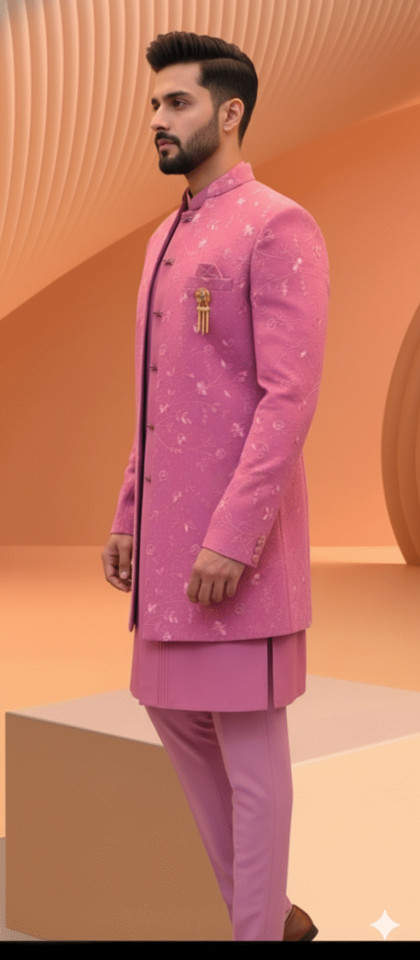 A man wearing a pink embroidered Indo-Western sherwani with a brooch and matching pants.