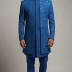 Teal blue Indo-Western set featuring intricate embroidery, paired with matching trousers, designed for festive and wedding occasions.