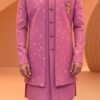 A man wearing a pink embroidered Indo-Western sherwani with a brooch and matching pants.