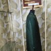 Dark green designer sherwani with zigzag pattern and golden buttons displayed