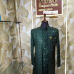 Dark green designer sherwani with zigzag pattern and golden buttons displayed