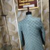 Elegant pastel green embroidered men’s designer sherwani displayed on a mannequin at Fenzi Designer Studio.