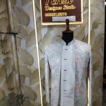 Pastel embroidered Jodhpuri suit displayed on a mannequin at Fenzi Designer Studio.