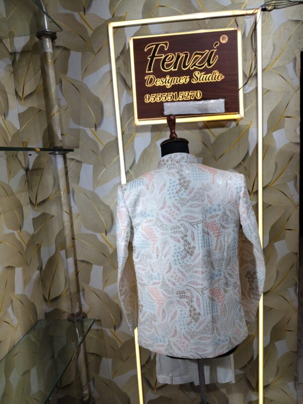 “White embroidered Jodhpuri suit with intricate pastel patterns displayed on a mannequin at Fenzi Designer Studio.”