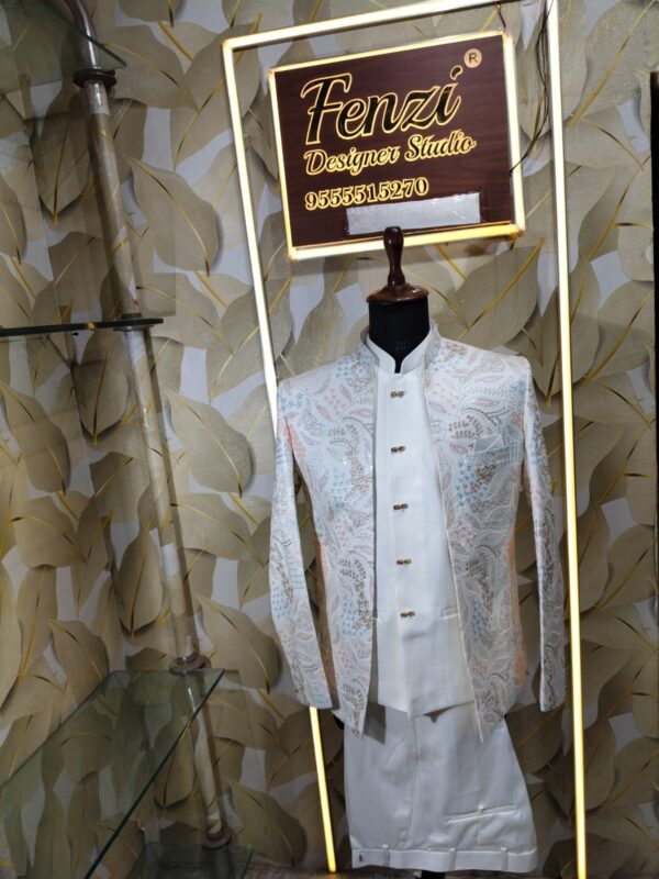 “White embroidered Jodhpuri suit with intricate pastel patterns displayed on a mannequin at Fenzi Designer Studio.”