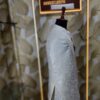 Cream-colored embroidered Jodhpuri suit displayed on a mannequin at a designer studio.