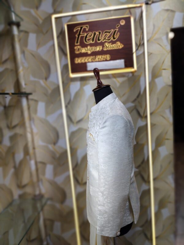 Cream-colored embroidered Jodhpuri suit displayed on a mannequin at a designer studio.